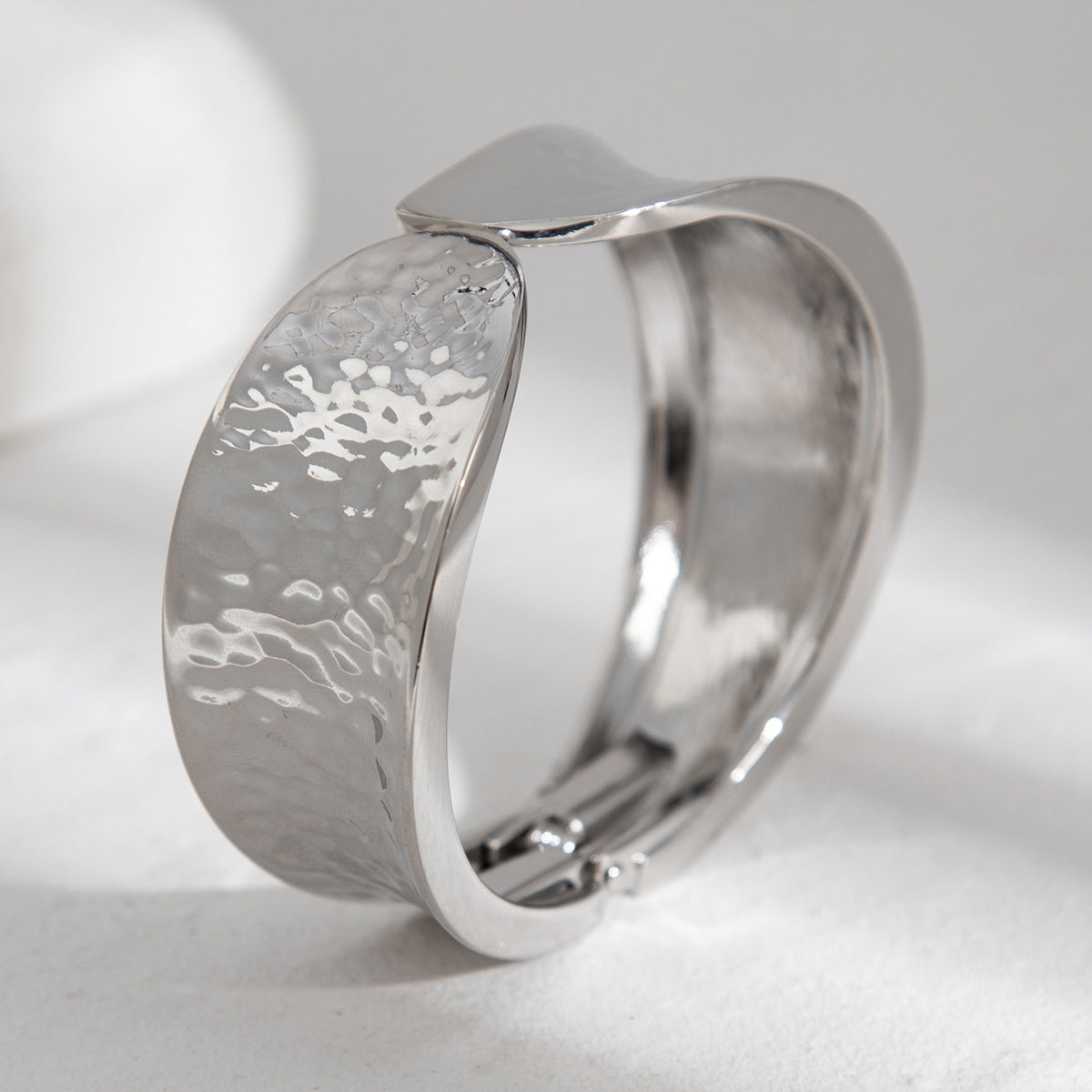 Bracelet à ressort, rond et lisse, au design sophistiqué et à l'aspect métallique irrégulier et tendance