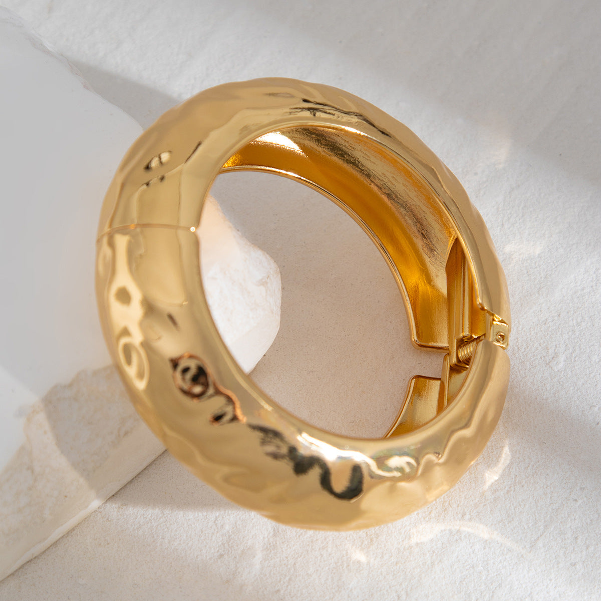 Bracelet à ressort, rond et lisse, au design sophistiqué et à l'aspect métallique irrégulier et tendance