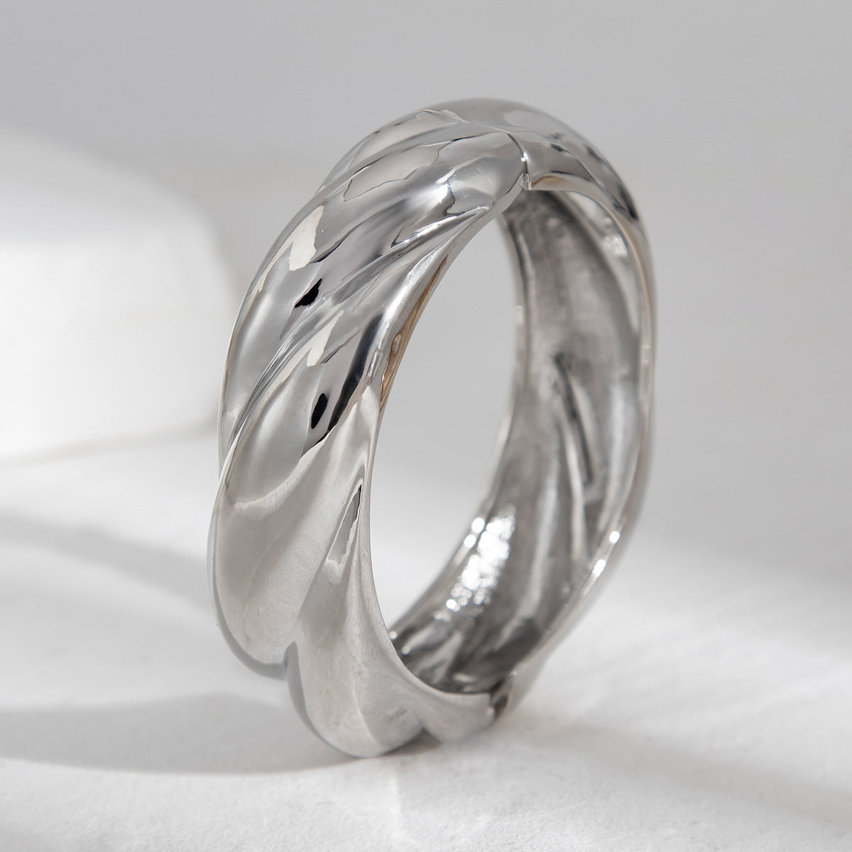 Bracelet à ressort, rond et lisse, au design sophistiqué et à l'aspect métallique irrégulier et tendance