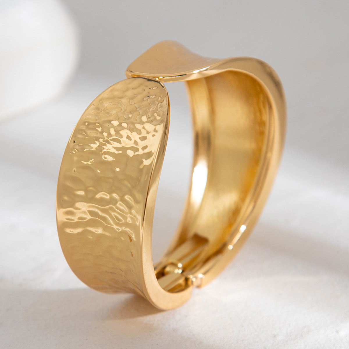 Bracelet à ressort, rond et lisse, au design sophistiqué et à l'aspect métallique irrégulier et tendance